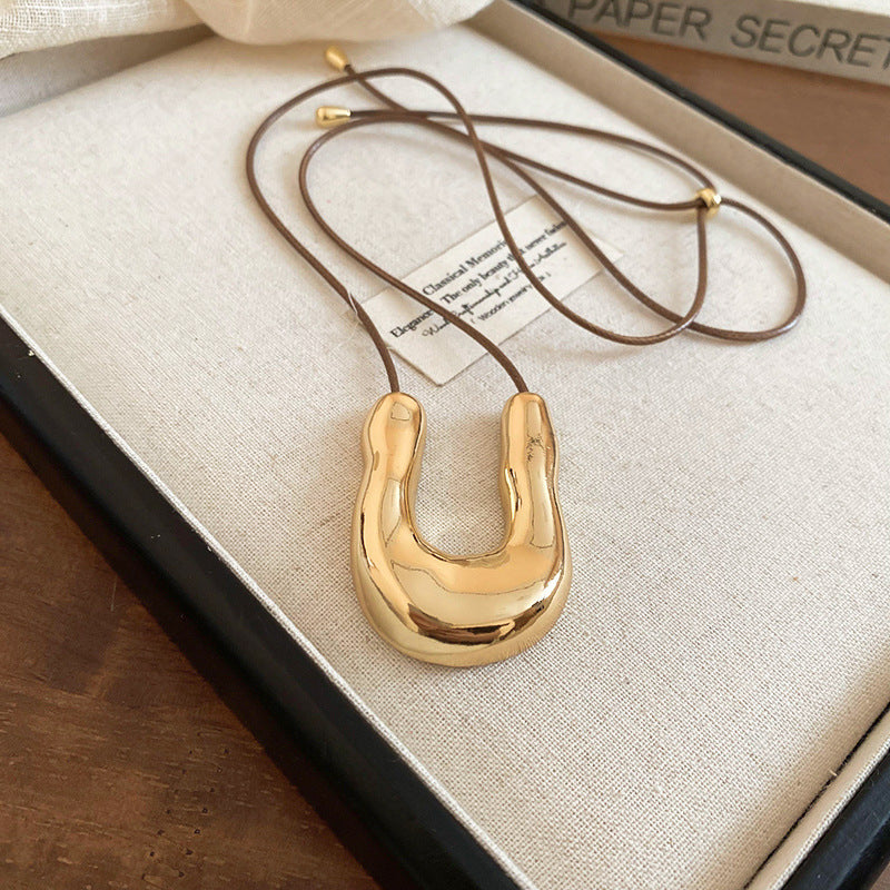 U-shaped Collier Tendance Femme  Pendentif Doré Sculptural sur Cordon Cuir Ajustable