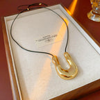 U-shaped Collier Tendance Femme  Pendentif Doré Sculptural sur Cordon Cuir Ajustable